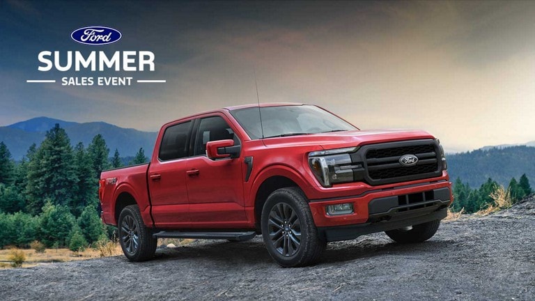 A 2024 Ford F-150® Lariat parked on a dirt road with mountains in the background