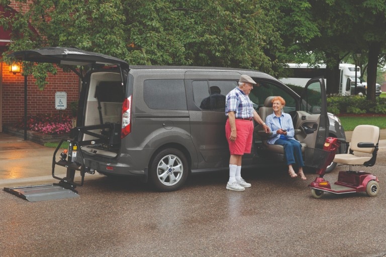 man helping disabled woman by a Ford Transit