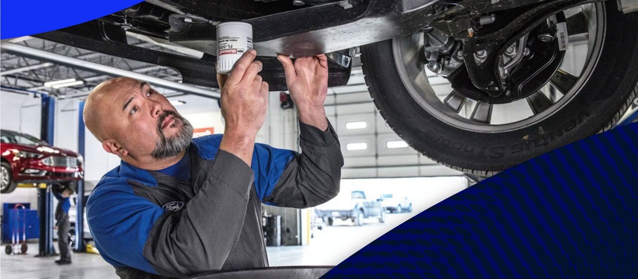 Ford Dealer Technician changing oil on a vehicle at the dealership