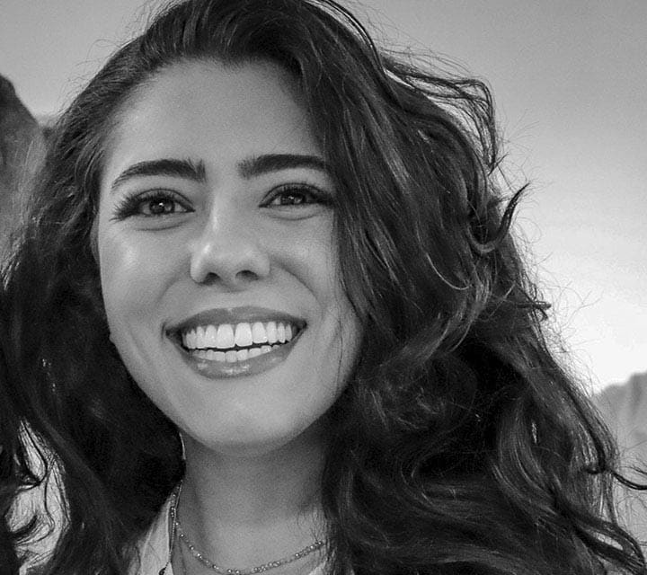 A close-up black and white portrait of Julia Matos, a woman innovator at Ford. Rollover of the photo enlarges her photo slightly. Clicking her photo takes you to her professional bio.
