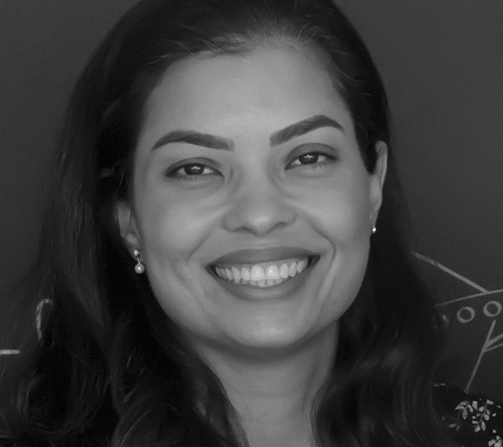 A close-up black and white portrait of Poliana Rocha, a woman innovator at Ford. Rollover of the photo enlarges her photo slightly. Clicking her photo takes you to her professional bio.