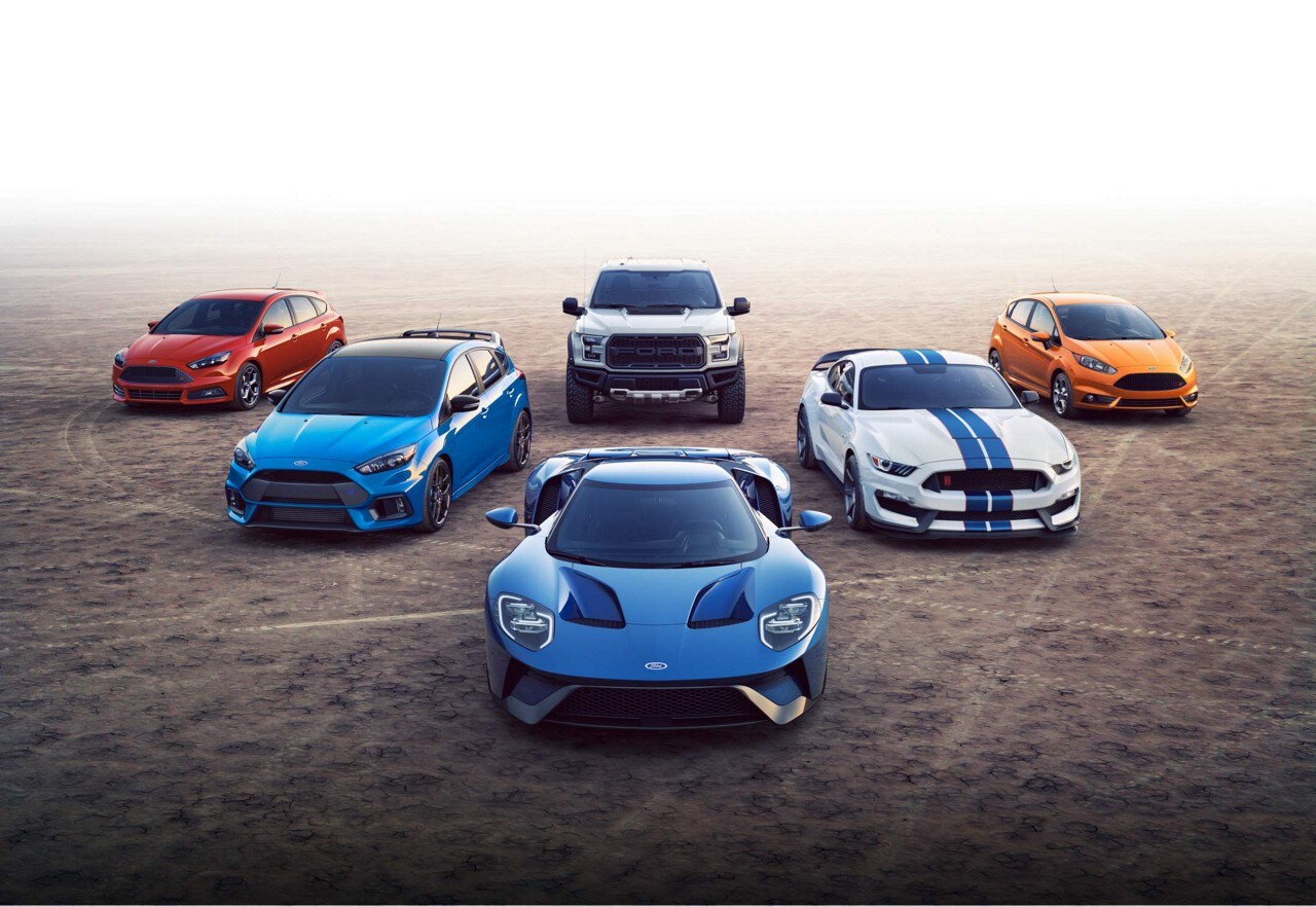Group of Ford performance vehicles parked on dry lake bed.