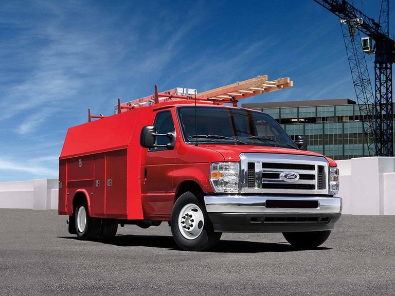 A red Ford E-Series Cutaway with a storage box upfit