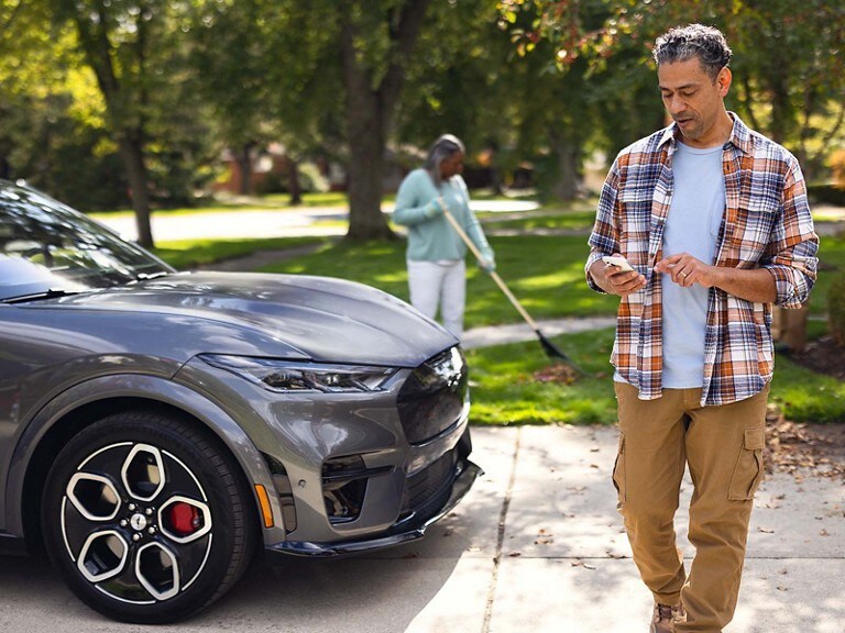 A man outside looking at his smartphone.