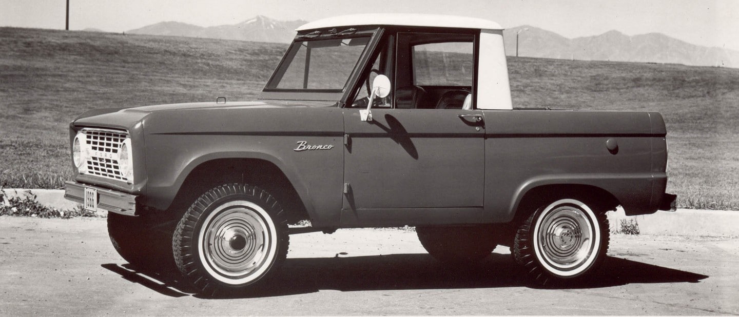 First generation 1966 Ford Bronco parked on street.