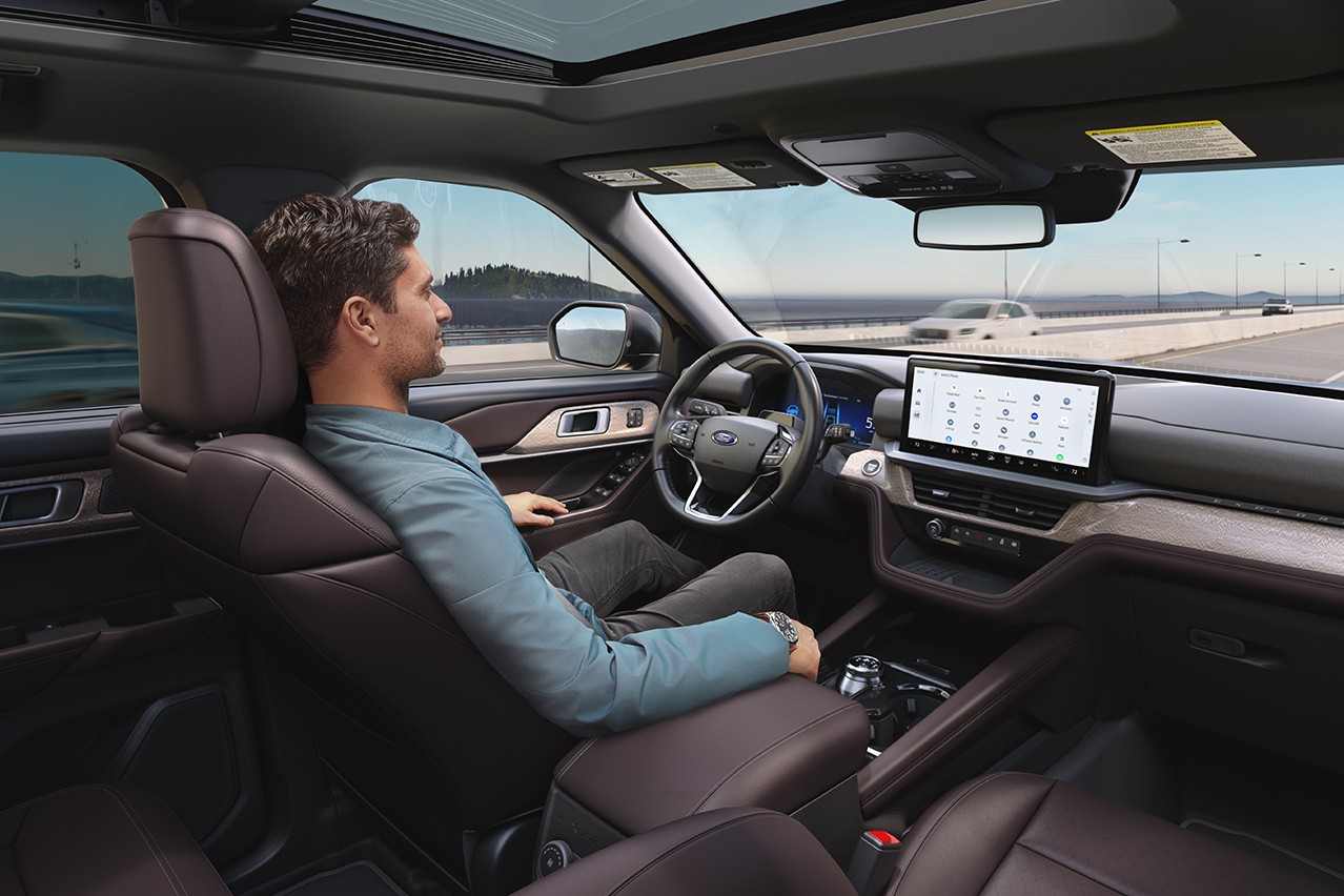 Interior of a 2025 Ford Explorer® with a driver looking at the road while using BlueCruise in a Blue Zone hands-free highway