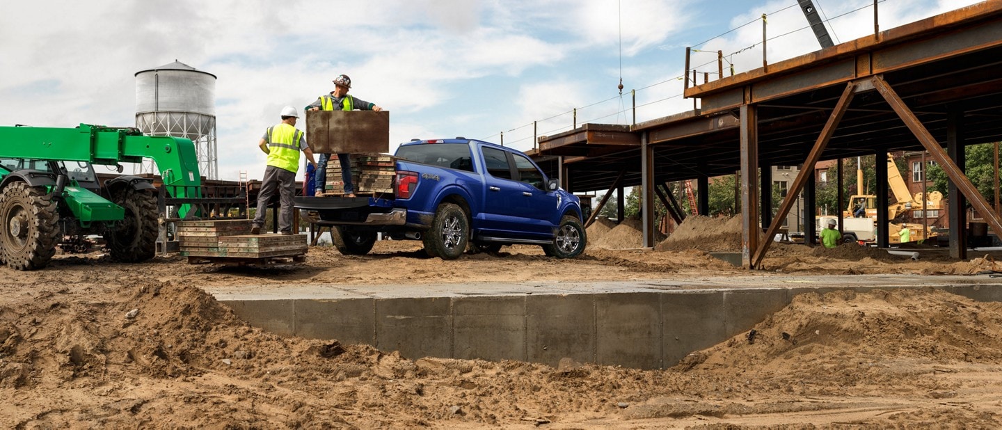 2026 Ford F-150® XLT parked on a construction site with material being taken out of truck bed