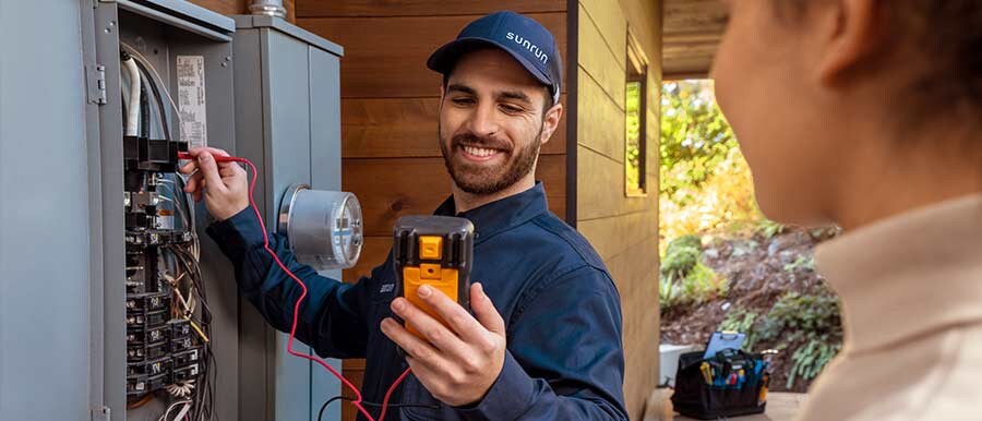 An electrician works on a home electrical box