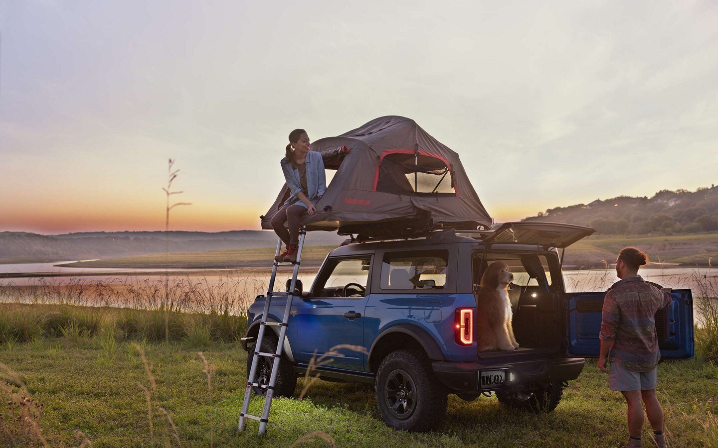 Una pareja acampando con una SUV Ford Bronco® 2023 con una carpa en el techo