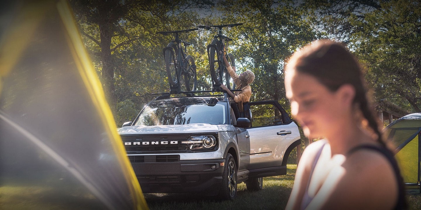 2023 Ford Bronco® Sport in background with a woman standing outside near the vehicle
