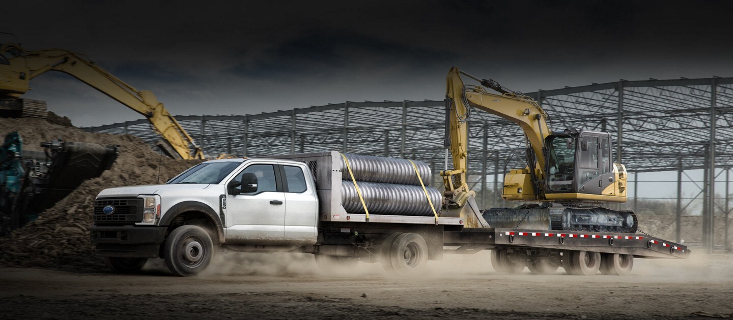 La Ford Super Duty® F-600® XLT Chassis Cab 2023 en Oxford White con mejora de plataforma en un sitio de construcción