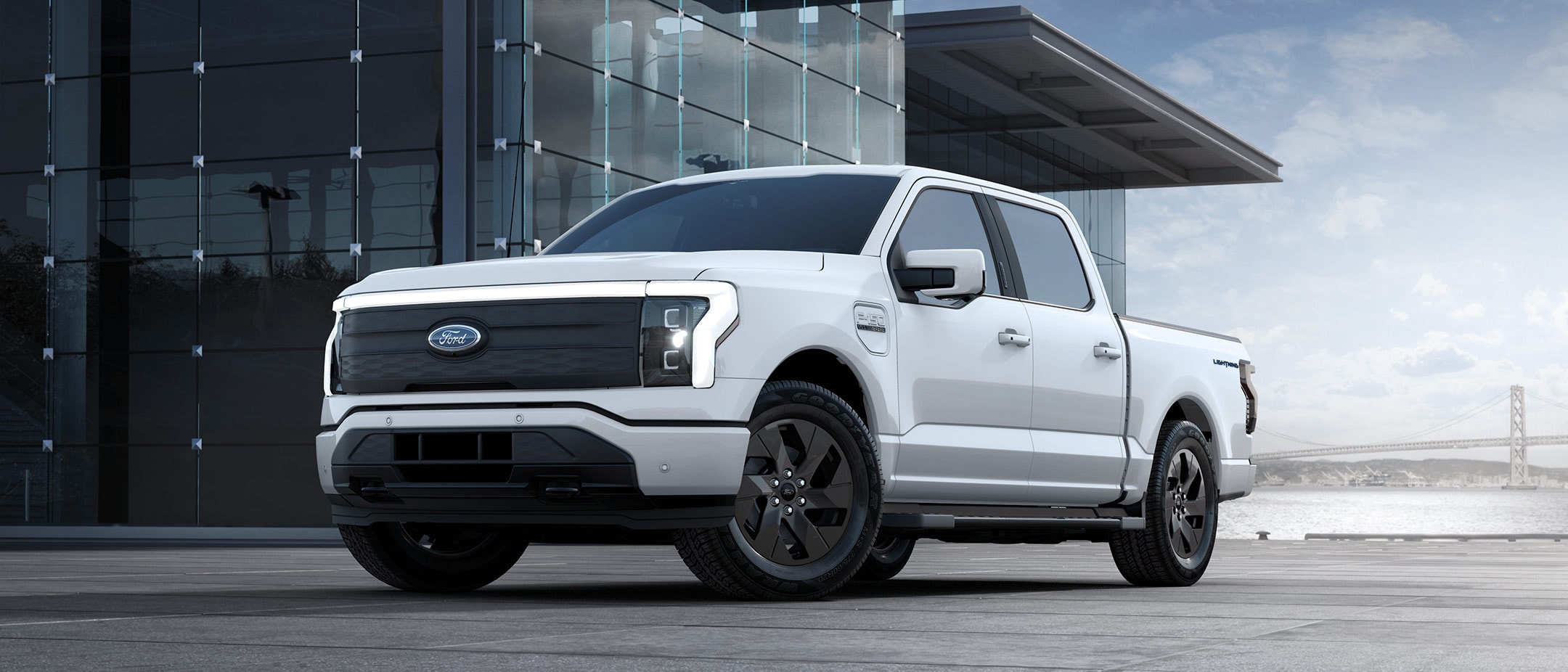  2024 white ford f-150 lighting parked in front of modern building