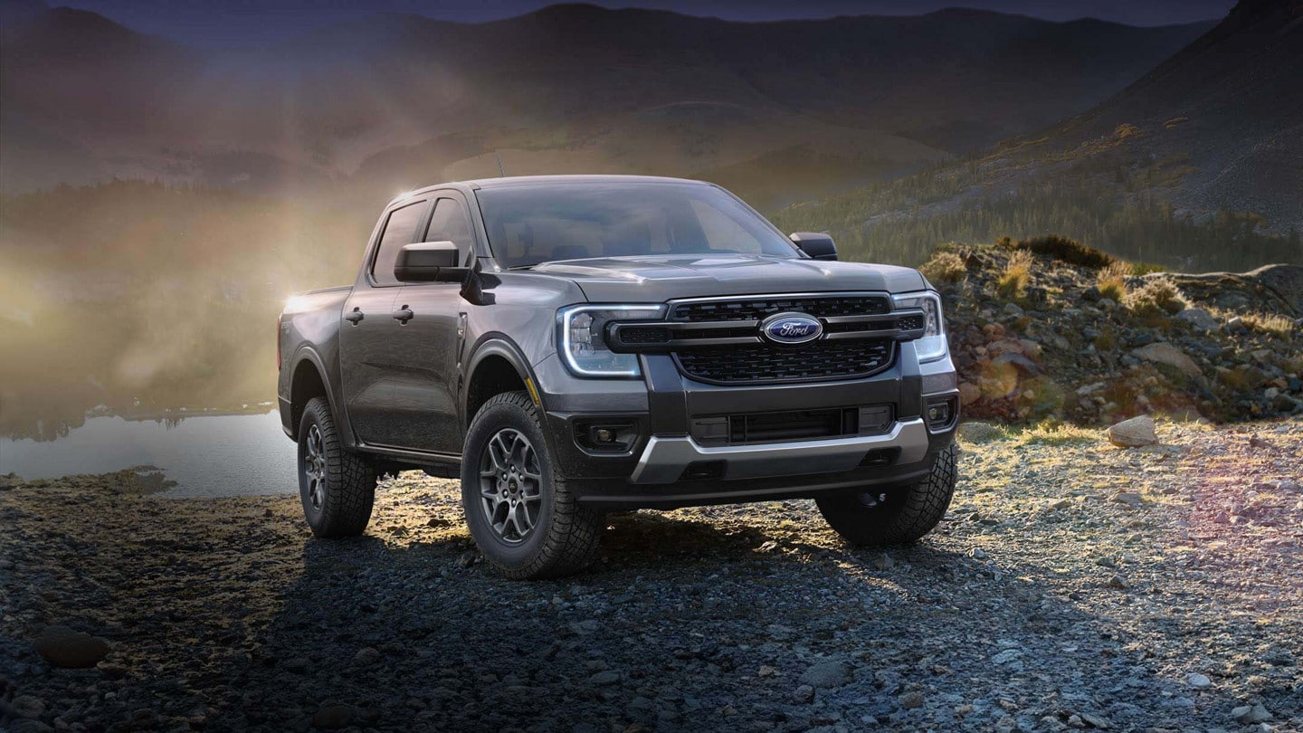 A 2024 Ford Ranger® in Carbonized Gray is parked by a lake during sunset