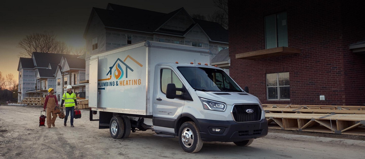 Una Ford Transit® Chassis Cab 2023 junto a dos personas en un sitio de construcción