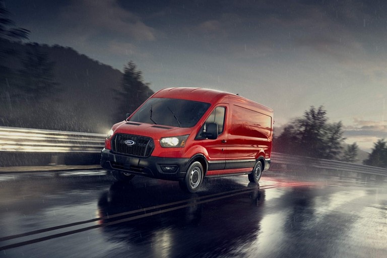 A 2026 Ford Transit® van being driven through a neighborhood