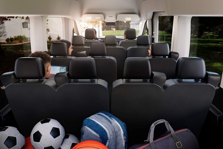 A 2026 Ford Transit® van being driven through a neighborhood