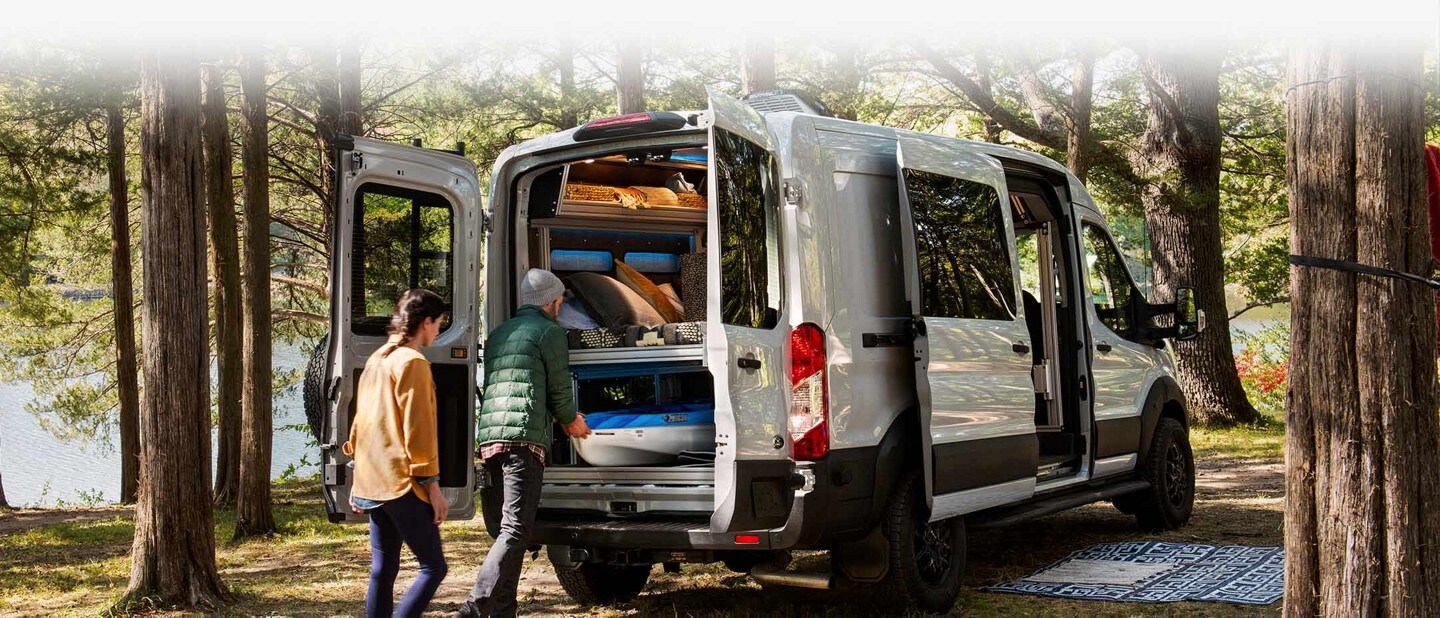 Una pareja descargando equipos de la parte trasera de una van Ford Transit Trail™ 2023