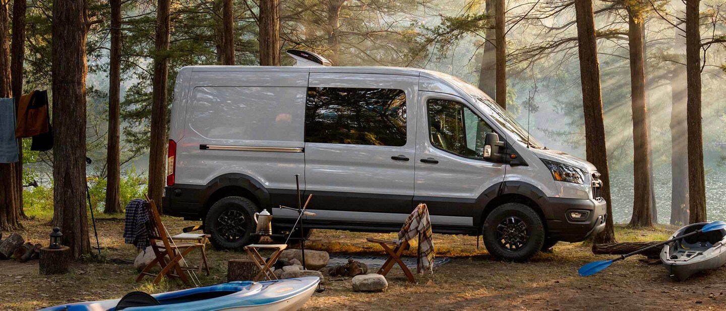 Una Ford Transit Trail™ Van 2023 estacionada en el bosque